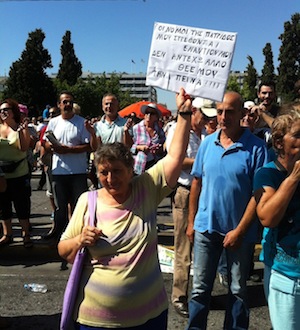 A woman at a strike holds a board with the words: “The law of my country has turned against me, God I cant stand hunger anymore." Credit: Apostolis Fotiadis/IPS 