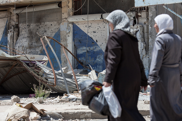 Women walk past destroyed shops in Al Qusayr, Syria. Credit: Sam Tarling/IPS