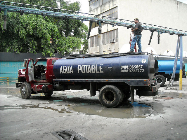 A tanker truck loads water in the El Paraíso neighbourhood on the south side of Caracas, to sell it in poor neighbourhoods or middle-class apartment buildings where the pipes often run dry. Credit: Raúl Límaco/IPS