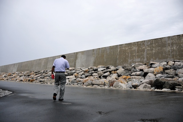 A man walks past the 10-foot wall near the boundary of the Southern Extension of the Colombo harbour, which was built as a protective measure against a future tsunami. Credit: Amantha Perera/IPS 