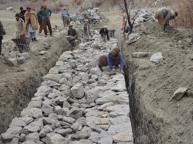 Labourers construct flood-control gabion walls - structures constructed by filling large galvanized steel baskets with rock – in northern Pakistan's remote Bindo Gol valley. Credit: Saleem Shaikh/IPS