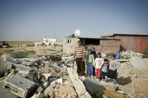 Naif Agele stands with his children and nephews by the ruins of his brother's house in an ‘unrecognised' section of the township of Kuseife in the Negev desert. The house took one month to build and was demolished by government authorities in 10 minutes in March 2014. Credit: Silvia Boarini/IPS