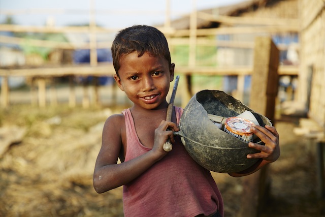 This boy spends his days selling betel nut in the traditional form, wrapped in a leaf with a bit of lime powder and tobacco. A salvaged halved buoy serves as his basket. Credit: Courtesy Rob Jarvis
