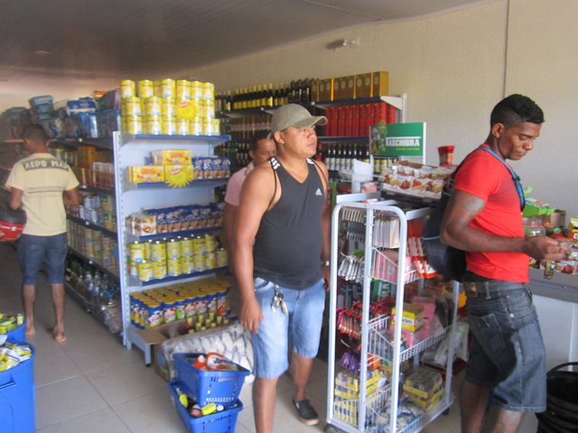 Francisco Assis Cardoso (dark tank top, centre), in his new supermarket. The young entrepreneur opened the grocery store and a pharmacy in Jatobá, the new neighbourhood in the city of Altamira where his entire family was relocated due to the construction of the Belo Monte dam in the Brazilian Amazon. Credit: Mario Osava/IPS 