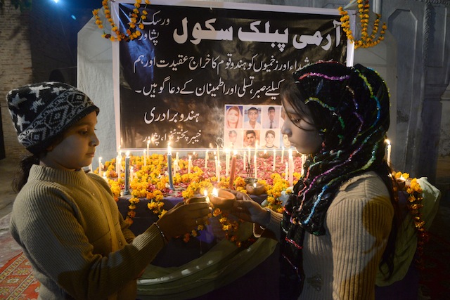 Girls light candles in memory of those who lost their lives in late 2014, when armed gunmen invaded and opened fire on hundreds of students and teachers in northern Pakistan. Credit: Ashfaq Yusufzai/IPS