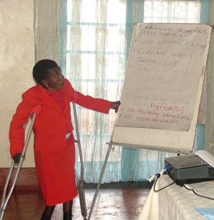 Shown in the photo donning a red dress, is Zipha Moyo, a disabled HIV/AIDS activist recently making a presentation Harare, the Zimbabwean capital on the exclusion of People with Disabilities in HIV and AIDS programs. Credit: Jeffrey Moyo/IPS