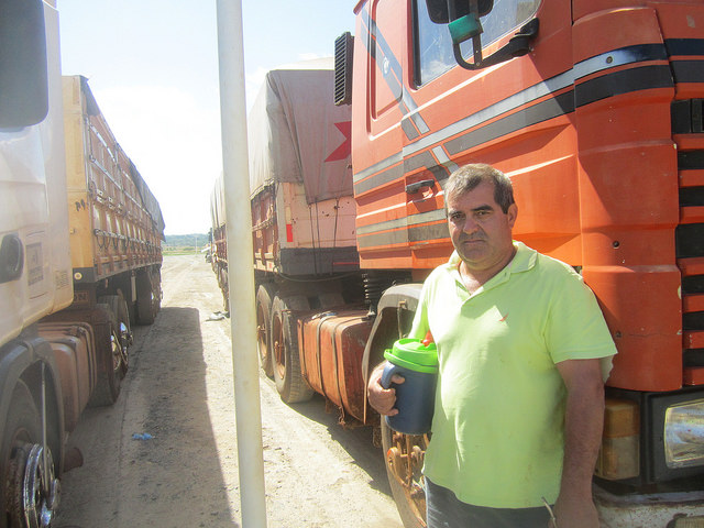 Martin Echauri says the Angostura Agroindustrial Complex SA (CAIASA) is "a blessing" because of how quickly he and his fellow truckers manage to unload the soybeans they haul in to the plant, which receives an average of 500 trucks a day in Angostura, in the industrial park in Villeta, Paraguay. While they wait, Echauri and other truckers drink "yerba mate", a caffeinated herbal brew that is popular in Paraguay, Argentina, Uruguay and southern Brazil, which they drink in a special thermos. Credit: Mario Osava/IPS