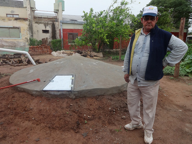 Local small farmer José Ramón Espinoza stands next to a recently constructed community tank for harvesting rainwater, which will enable a group of families to weather the recurrent drought in Corzuela, a rural municipality in the northeast Argentine province of Chaco. The underground tank was provided by GEF's Small Grants Programme. Credit: Fabiana Frayssinet/IPS