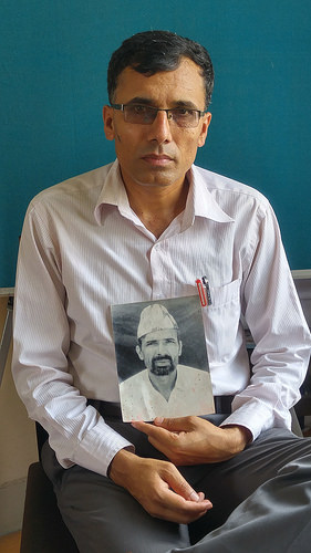 Suman Adhikari, chairperson of Nepal's Conflict Victims Common Platform, holding a photo of his father. Credit: Marty Logan/IPS