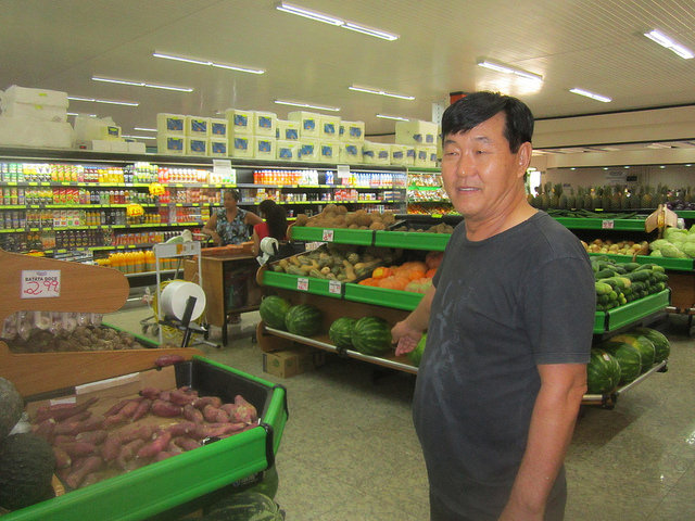 Pedro Kingfuku, owner of four supermarkets, stands among fruit and vegetables that come from Paraná, 2,000 km south of Paranaita, a municipality with a population of 11,000 people. Local family farming has a great capacity for expansion to cater to the large market in the north of the state of Mato Grosso, in west-central Brazil. Credit: Mario Osava/IPS