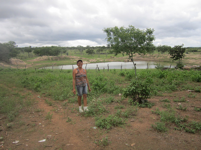 Normaleide de Oliveira stands in front of the pond on her farm that did not even run out of water during the six years of drought suffered by Brazil's Northeast region. Water availability is an advantage of family farmers in the Jacuípe river basin, compared to other areas of the country's semi-arid ecoregion. Credit: Mario Osava / IPS