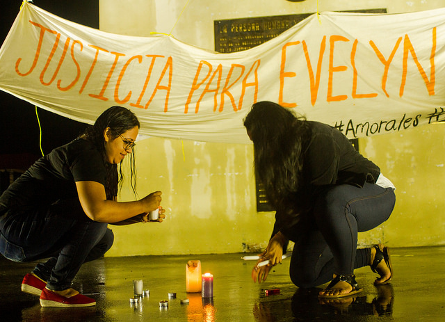 Two women light candles in front of the monument to the constitution in El Salvador's capital, during a protest against the sentencing of a young woman to 30 years in prison, accused of having had an abortion. Credit: Edgardo Ayala/IPS