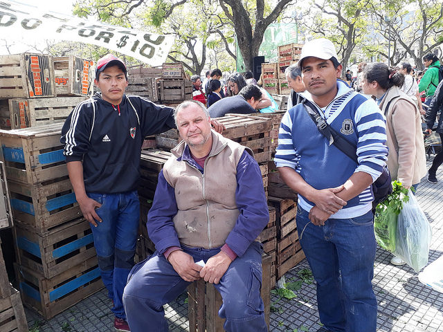 Roberto Eizaguirre, Guillermo Riquelme and Mario Garcia (left to right), farmers from the rural area of La Plata, Argentina, during the fair that small farmers set up in a central square in Buenos Aires to sell their vegetables directly to consumers at prices much lower than those seen in stores. Credit: Daniel Gutman/IPS