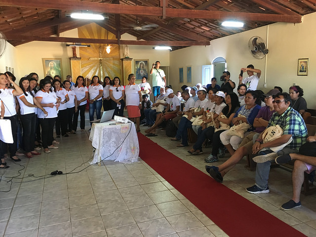 The 19 women who operate the Community Bakery of Varzea Comprida dos Oliveiras, a settlement in the municipality of Pombal, in the Northeast region of Brazil, sing at the reception for journalists and young people from Brazil, Peru, Bolivia and Chile, in the local parish church. The bakery runs on solar energy, recycles grey water and uses biogas produced by a biodigester. Credit: Orlando Milesi/IPS