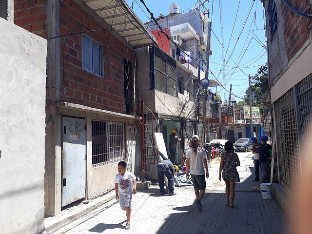 A street in Villa 31, with informal dwellings up to five storeys high and tangles of electric cables unofficially connected to the grid. More than 43,190 people live in the shantytown, according to the Buenos Aires city government, which in 2016 launched an ambitious plan to urbanise the neighbourhood. Credit: Daniel Gutman/IPS