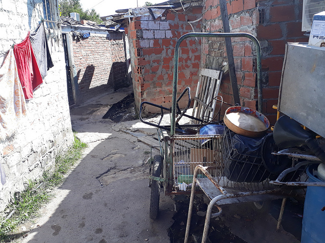 Outside a house are seen a cart and some of the odd objects found by garbage pickers, the informal work on which many of the people of La Cava, a shantytown on the north side of Buenos Aires, depend. Credit: Daniel Gutman/IPS