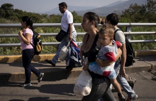 A Venezuelan family carrying a few belongings crosses the Simon Bolivar Bridge at the border into Colombia. Over the years, the migration flow has grown due to increasing numbers of people with unsatisfied basic needs. CREDIT: Siegfried Modola/UNHCR