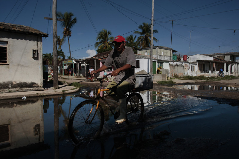 A man rides his bicycle along a flooded street in the town of Batabanó, in southern Mayabeque province in western Cuba, an area of low-lying, often swampy coastal areas prone to frequent flooding during hurricanes and heavy rains. CREDIT: Jorge Luis Baños/IPS