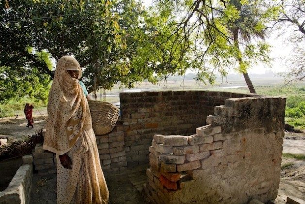 A Dalit woman stands outside a dry toilet located in an upper caste villager’s home in Mainpuri, in the northern Indian state of Uttar Pradesh. A caste-based profession, manual scavenging condemns mostly women, but also men, to clean human excreta out of dry latrines with their hands, and carry it on their heads to disposal dumps. Many also clean sewers, septic tanks and open drains with no protective gear. Credit: Shai Venkatraman/IPS
