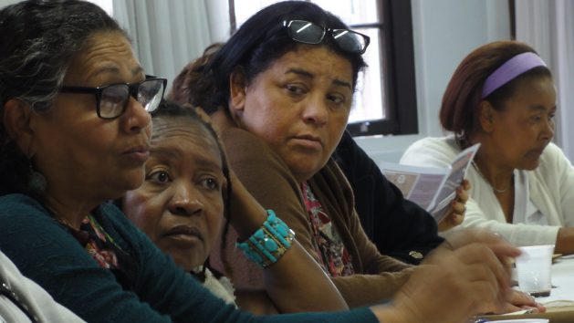 Faces of a group of domestic workers in Brazil, during a meeting of one of their unions – a reflection that they are mostly black and poor. They have been fighting for decades for their labor recognition and rights. Today they are organized in 22 unions in states or municipalities and, since 1997, they have a national federation that represents them. CREDIT: Trabalhadoras Domésticas/Flickr