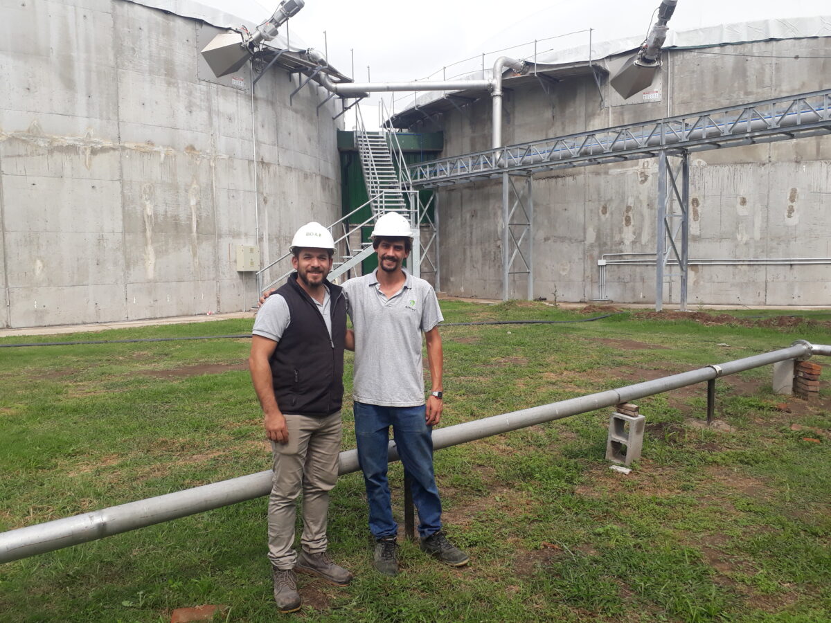 Ezequiel Weibel (l) and Ezequiel Tamburrini stand with two of the three biodigesters in the background in Zárate, 90 kilometers from the capital of Argentina, which will convert waste from the agri-food industry into biogas. CREDIT: Daniel Gutman/IPS