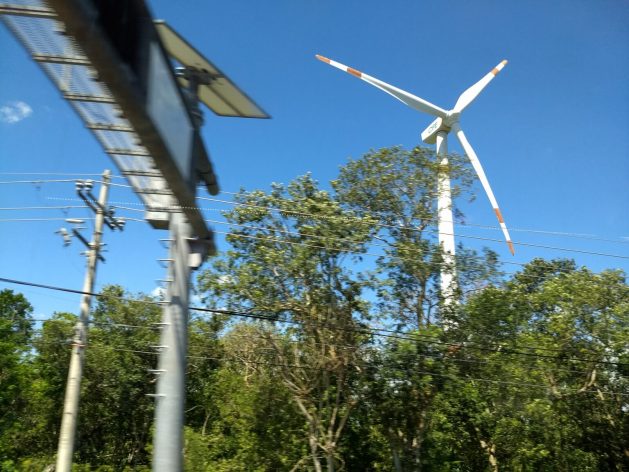 The Yucatán peninsula in southeastern Mexico has abundant solar and wind resources, but relies on fossil fuels for electricity generation. The photo shows a wind turbine belonging to the state-owned CFE next to a section of the power grid between Cancún and Puerto Morelos, in the state of Quintana Roo. CREDIT: Emilio Godoy/IPS