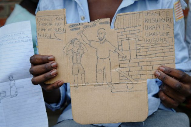 A child beneficiary holding a drawing portraying domestic violence, at the Centre for Youth Empowerment and Civic Education, Lilongwe, Malawi which partnered with the ILO/IPEC to support the national action plan aimed at combating child labour. Credit: Marcel Crozet/ILO