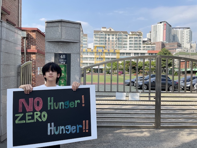 Chris Ham, Seocho Middle School, Seoul, Korea: “I am holding up a large sign to passionately champion the increase of awareness on the severity of the hunger issue.” 
