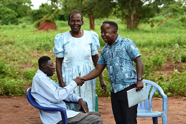 BRAC Proje Asistanı Derick Baguma, çiftçilik girişimlerine yardımcı olmak için Lawrence Akena ve annesi Lili Iram'ı düzenli olarak ziyaret ediyor.  Kredi bilgileri: BRAC 