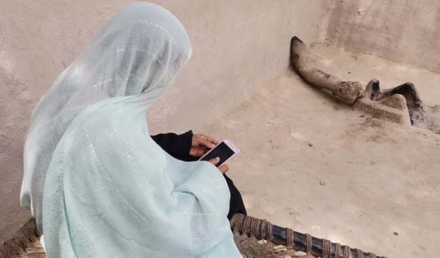 Uzma of Ahmedpur Lama village, Punjab province, using her mobile phone at home. Credit: Irfan Ulhaq/IPS