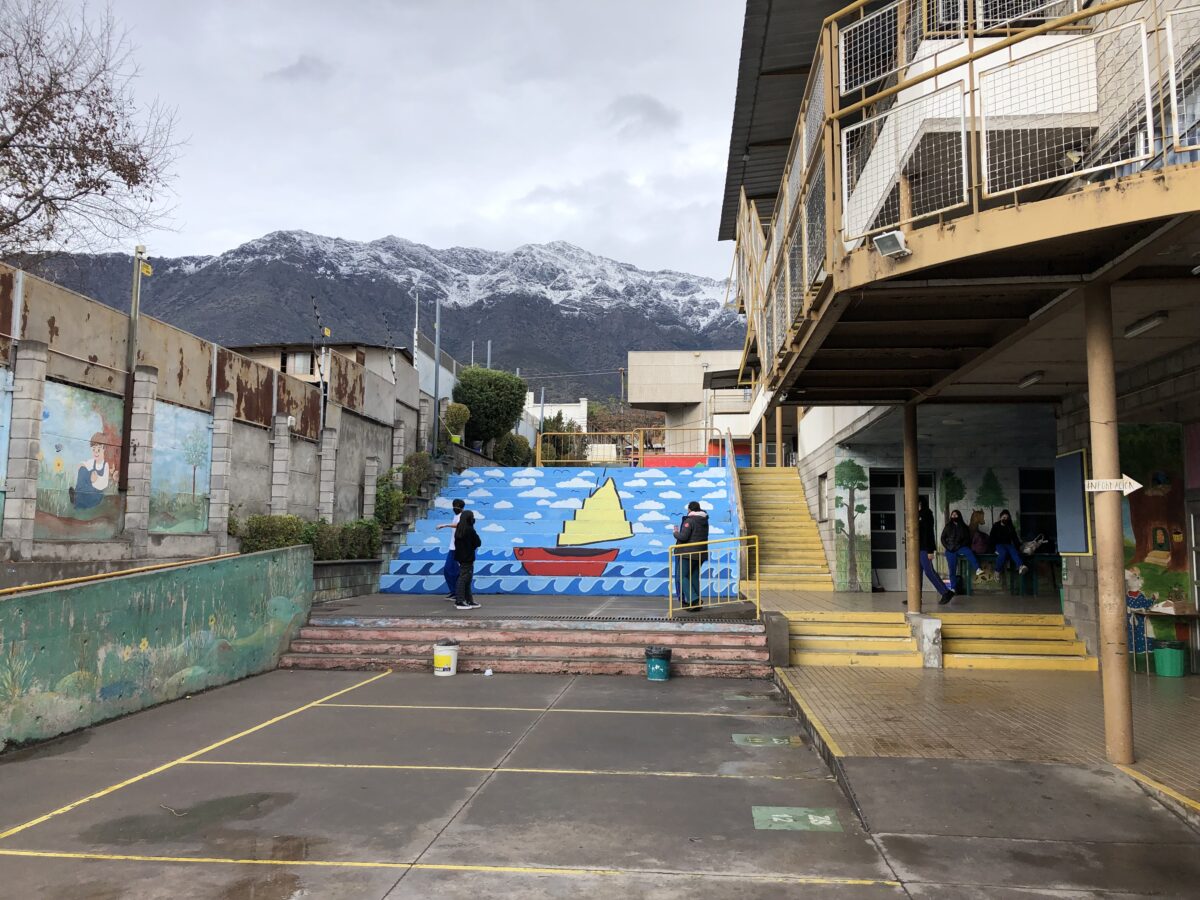 A colorful mural decorates the staircase leading to the second story of classrooms at the primary school in Peñalolén, located in the snowy Andes foothills seen here in the background in the middle of Chile's southern hemisphere winter. CREDIT: Orlando Milesi/IPS - A Chilean government plan seeks to ensure connectivity in remote areas, in a first step to address a deep digital divide among the country's inhabitants that includes a lack of access to technology and digital education deficits, exposed by the COVID-19 pandemic