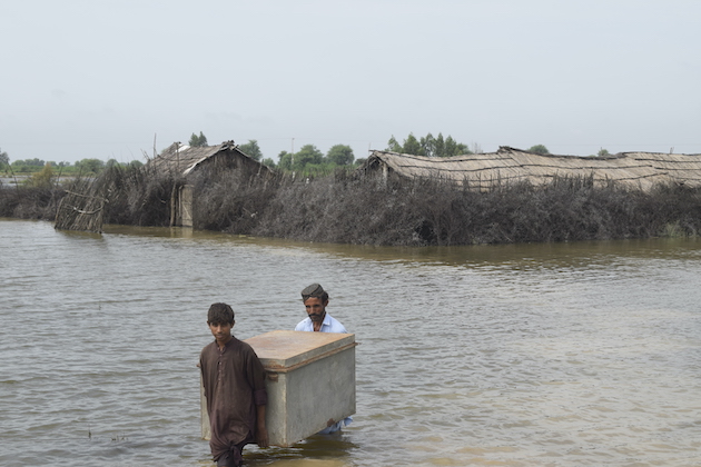 Een vader en zoon halen hun bezittingen uit hun door overstromingen beschadigde huis in Taluka, Shujabad, District Mirpurkhas Taluka, Shujabad, District Mirpurkhas.  Krediet: Stichting Onderzoek en Ontwikkeling (RDF)