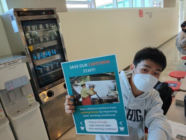 Soo Hyoun Lim's classmate doing a campaign inside the Yongsan International School’s cafeteria with the poster.