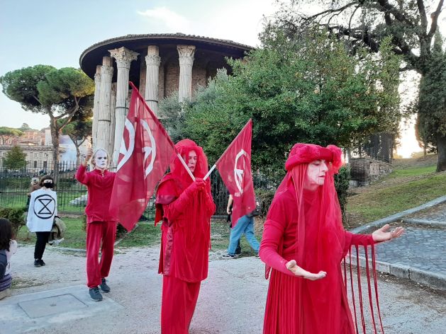 XR Red Rebels at a climate protest in Rome. Credit: Paul Virgo/IPS - They are inspired by examples of the successful use of civil disobedience in the past, such as with the Suffragettes and the civil rights movement in the United States.