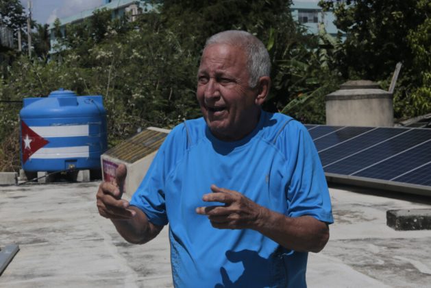 Félix Morffi, an 84-year-old retiree, shows a self-made solar heater and solar panels installed on the roof of his house in the municipality of Regla in Havana. His hope is that his house will soon become an experimental site for the use of renewable energies and that students will learn about the subject in situ. CREDIT: Jorge Luis Baños/IPS