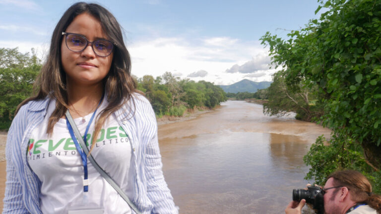 Dalia González, of the Salvadoran movement Green Rebellion, on the banks of the Ostúa River in eastern Guatemala, talks about the impact that pollution from the Cerro Blanco mine will have on the river, which in turn will end up polluting the Lempa River in El Salvador. CREDIT: Edgardo Ayala/IPS