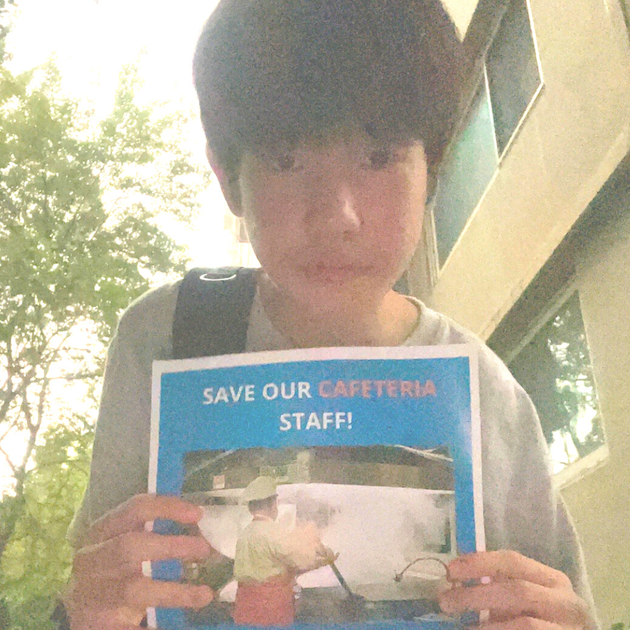 Hyeonuk Hwang holds the poster in public to raise awareness of the dangers school cafeteria workers face.