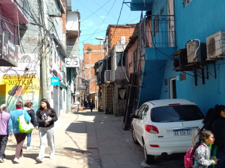 Buenos Aires'in kalbinde yer alan bir gecekondu mahallesi olan Padre Mugica semtindeki geçitlerden birinin görünümü.  Enformel yerleşimin düzenlenmesi ve kentle bütünleştirilmesi süreci 2015'te başladı, ancak henüz yarılandı ve güvencesiz konutlarla çevrili dar geçitler modern yollar ve binalarla bir arada var.  KREDİ: Daniel Gutman/IPS