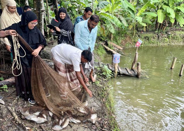 Mosammat Mahmuda catches fish with nets from her pond, where she raises different types of fish for commercial purposes in Badarkhali, Barguna district, southern Bangladesh, in September 2022. Source: Farid Ahmed/IPS