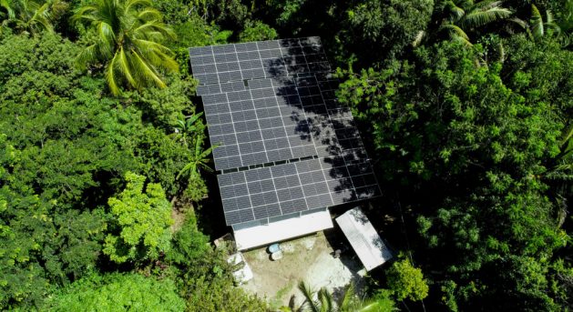 Aerial view of the community water system located in the canton of El Zapote, in the municipality of Suchitoto in central El Salvador. Mounted on the roof are the 96 solar panels that generate the electricity needed to power the entire electrical and hydraulic mechanism that brings water to more than 2,500 families in this rural area of the country, which in the 1980s was the scene of heavy fighting during the Salvadoran civil war. CREDIT: Alex Leiva/IPS
