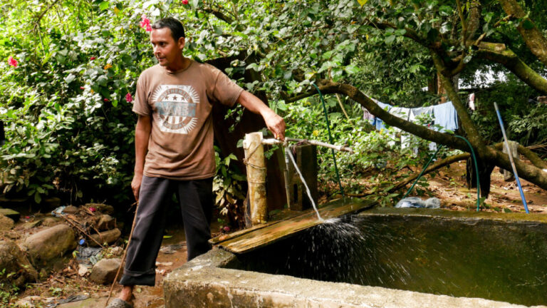 Een lokale inwoner van de gemeente Sitio el Zapotal in het kanton El Zapote, El Salvador, draait de kraan open om zijn gootsteen te vullen om het water op te vangen dat hij die dag nodig heeft.  Sinds 2010 hebben in totaal 10.000 mensen geprofiteerd van de vijf gemeenschapswaterprojecten op zonne-energie in El Salvador. CREDIT: Edgardo Ayala/IPS