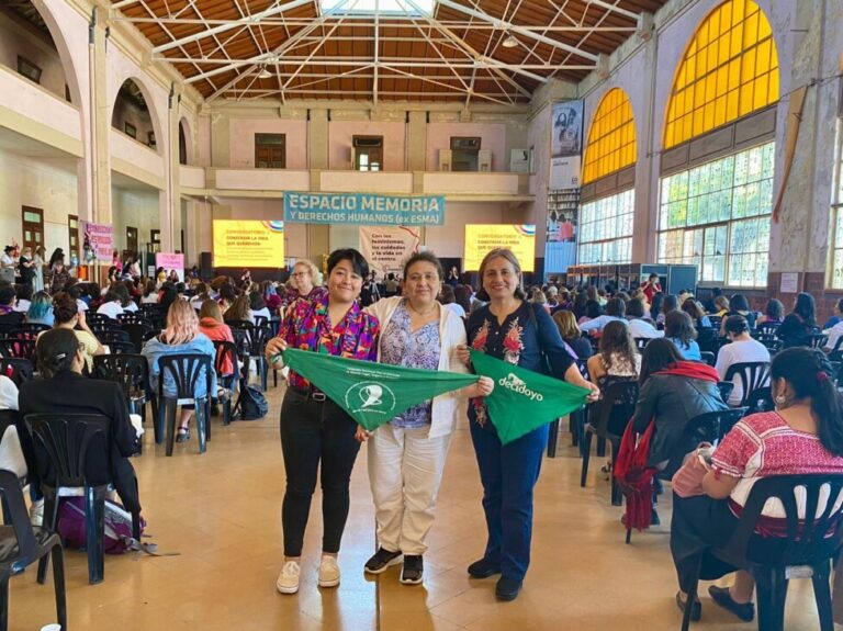 Obstetrician Rocío Gutiérrez (C), deputy director of the feminist Manuela Ramos Movement, stands with two fellow activists holding green scarves – representing the struggle for reproductive rights - during the XV Regional Conference on Women held this month in the city of Buenos Aires. CREDIT: Courtesy of Rocío Gutiérrez