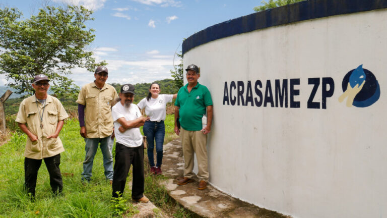 Het gemeenschapswaterproject in de Salvadoraanse gemeenschap Sitio El Zapotal werd gedreven door de inspanningen van lokale bewoners en internationale donoren.  Aan de voet van de opvangtank staan ​​Karlyn Vides van CoCoDA, adviseur en voormalig guerrillastrijder René Luarca (voor) - lid van het waterschap van het project - en voormalig guerrilla Luis Antonio Landaverde (links), samen met twee technici.  CREDIT: Edgardo Ayala/IPS