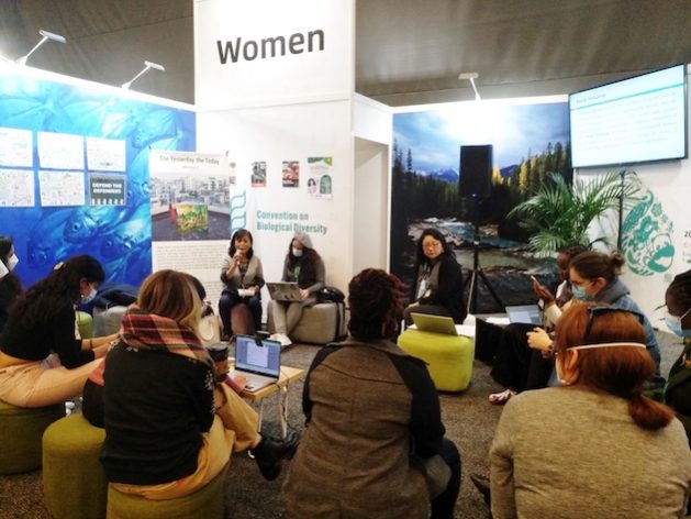 Women doing on-the-spot training at COP15. Target 22 is being held up by a single word. Credit: Stella Paul/IPS