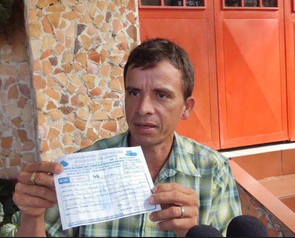 Jonathan Pernía, the impoverished father of a little girl who died when an ambulance was prevented from crossing the border between Venezuela and Colombia to give her emergency treatment, shows journalists the bill for the funeral expenses, which he has not been able to cover either. CREDIT: Courtesy of Bleima Márquez