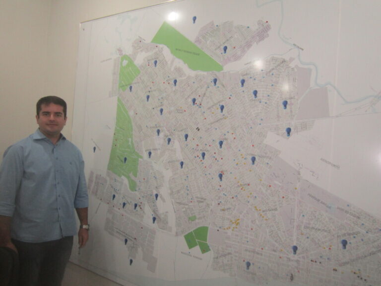 The secretary of Public Services and Environment of Boa Vista, Thiago Amorim, stands next to a map of the city which shows the areas already illuminated by energy-efficient LED bulbs. They now light up 80 percent of the city, which stands out for its solar energy generation and for programs that prioritize children, coordinating and combining educational, health and social action policies. CREDIT: Mario Osava/IPS