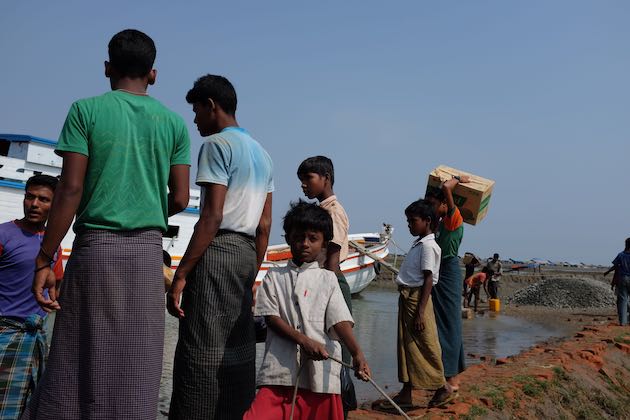 Muslim Rohingya IDPs wait for aid to be unloaded in Pawktaw camp in Rakhine State, an hour by boat from the main city of Sittwe. Credit: Sara Perria/IPS 