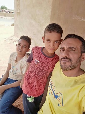 Ahmed Saber with two of his children. His son, Sabre Nasr, died when he was unable to access medical attention due to the conflict in Khartoum, Sudan.