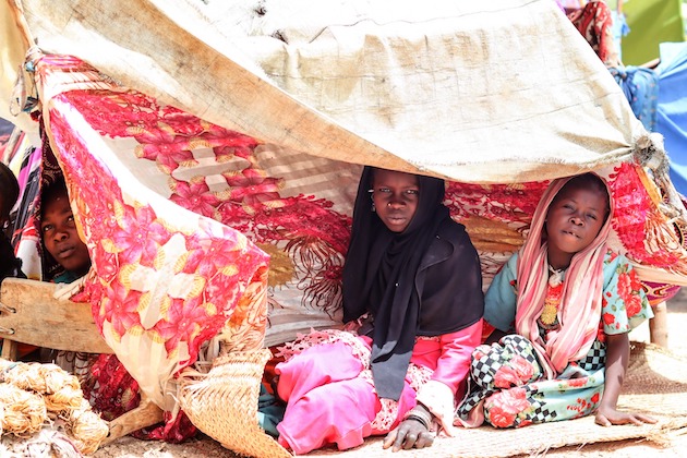 دختران جوان در بوروتا از پناهگاه‌های موقت خود نگاه می‌کنند.  تقریباً 70 درصد از کسانی که از درگیری اخیر سودان به چاد گریخته اند، کودکان مدرسه ای هستند.  اعتبار: ECW