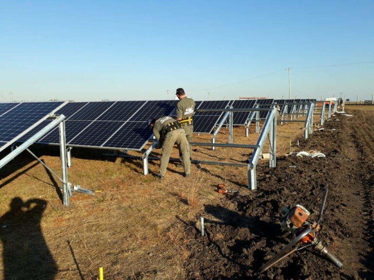 Two workers carry out maintenance tasks at the solar park in Monte Caseros, a town in the Argentine province of Corrientes, in the northeast of the country.  The park was inaugurated in 2021 by the local cooperative, which provides electricity to residents and is also engaged in agricultural activities.  CREDIT: Monte Caseros Agricultural and Electricity Cooperative